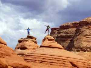KC and Brian balancing on top of rock formations near the Delicate Arch